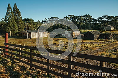 Shabby shacks from a ranch with wooden fence Stock Photo