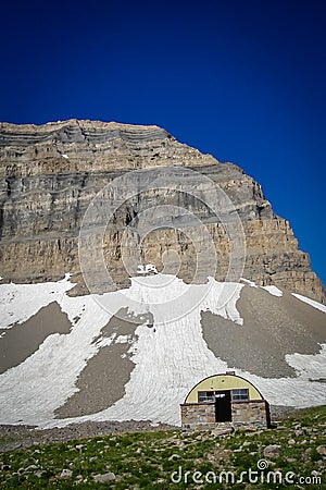 Mountain Shack Below Mountain Peak Stock Photo