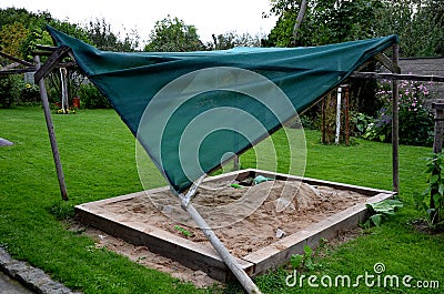 A shade of wooden poles fell on the sandpit in the family garden with a strong wind and rot of wood. the accident was avoided with Stock Photo