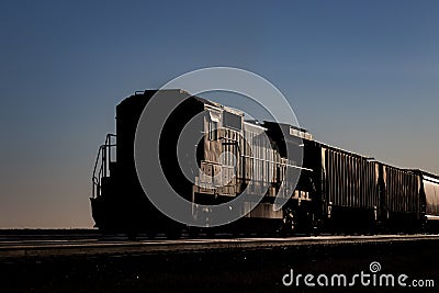 Shaded Locomotive on the end of a Freight Train Under Blue Sky Stock Photo