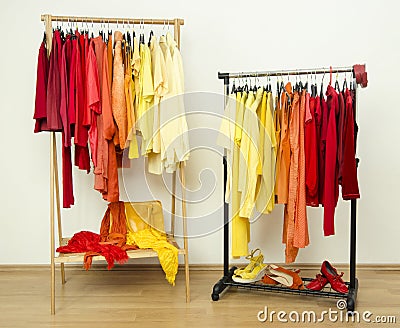 Shades of yellow, orange and red clothes hanging on a rack nicely arranged. Stock Photo