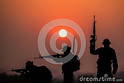 The shadow of the battle of soldiers on battlefield patrolling at sunset Stock Photo