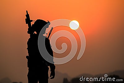 The shadow of battle of soldiers on the battlefield patrolling at sunset Stock Photo