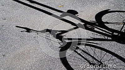 Shadow of bicycle projected onto asphalt in the sun. conceptual abstract image for travel, sport Stock Photo