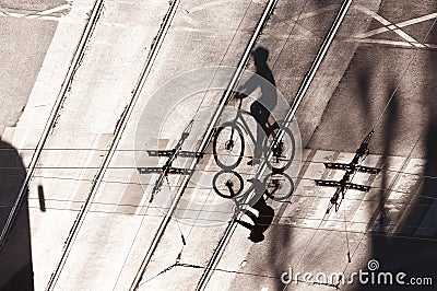 Shadow of a cyclist on a road with tram rails Stock Photo