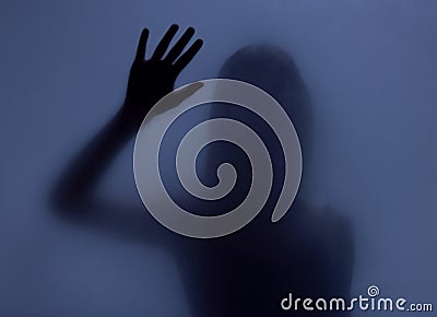 Shadow, glass and hand with a woman in studio on a blue background for mystery or sensual secrecy. Creative, silhouette Stock Photo