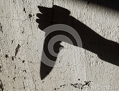 Shadow of the hand holding a knife Stock Photo