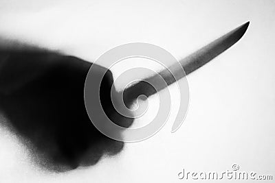 Shadow of hand holding knife Stock Photo