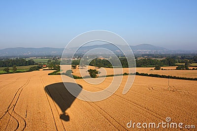 The Shadow of a hot air balloon flying over rural farmland Stock Photo