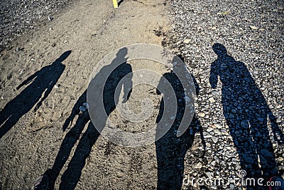 Shadow of people walking the road during sunset Stock Photo