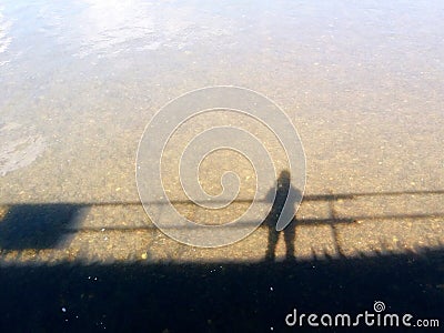 Shadow of person or silhouette alone standing on the bridge and reflection on the river Stock Photo