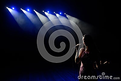 Shadow of singer in light on the stage Stock Photo