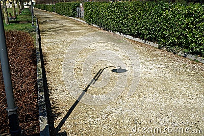 Shadow of street lamp in sunny day, road lantern in park Stock Photo