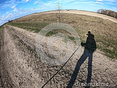 Shadow of a traveler with a cane in his hand. Landscape shot on fisheye lens Stock Photo