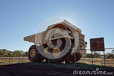 Shadow of Unit Rig Lectra Haul Mark 36 Dump Truck near Tom Price museum and iron ore mines in strong backlight Editorial Stock Photo
