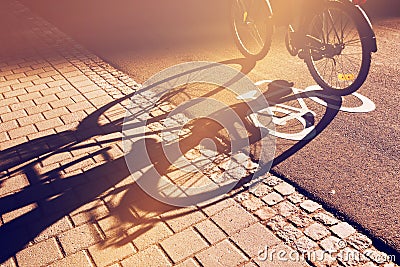 Shadow of unrecognizable cyclist on bicycle lane Stock Photo