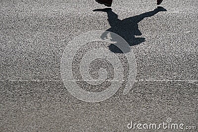 Shadow of an unrecognizable runner on asphalt Stock Photo