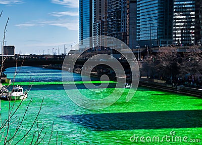 Shadows of buildings cast along the Chicago River which is dyed green for St. Patrick`s day Editorial Stock Photo