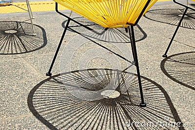 Shadows cast by a group of Acapulco lounge chairs Stock Photo