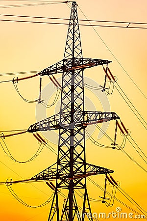 Shadows of energy transmission towers. High voltage tower silhouette sunset. Stock Photo