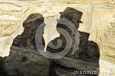 Shadows of a pair of lovers on the big rocks of a medieval castle Stock Photo