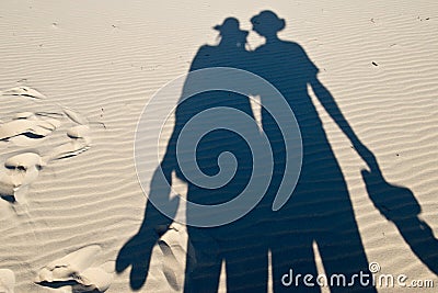 Shadows of pair of tourists on sand Stock Photo