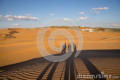 Shadows of people in XiangshaWan, or Singing sand Bay, in hobq or kubuqi desert, Inner Mongolia, China during sunset Stock Photo