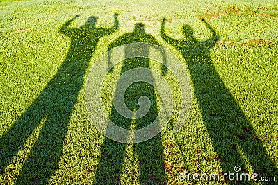 Shadows from three people on a grass Stock Photo