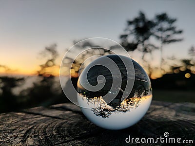 The shadows of the trees and houses in the morning reflect on the crystal ball before sunrise. Stock Photo