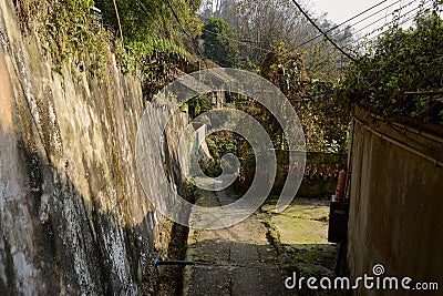 Shady hillside path in ancient dwelling buildings Stock Photo
