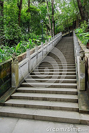 Shady hillside stone stairway witn balustrade in summer woods Stock Photo