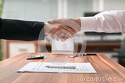 Shakehand of lawyer and business woman sitting behind desk with agreement Stock Photo