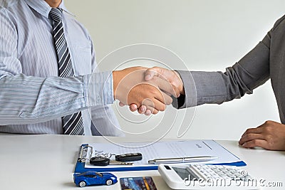 Shaking hands, Car dealership provides advice about insurance details and car rental information and delivers the keys Stock Photo