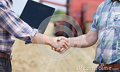 Shaking hands on farmland Stock Photo