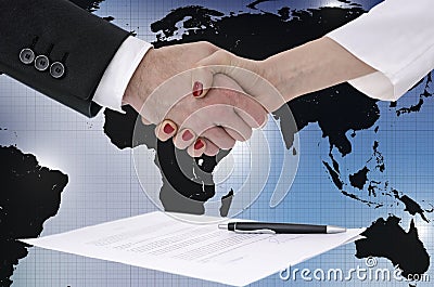 Shaking hands over map of the world Stock Photo