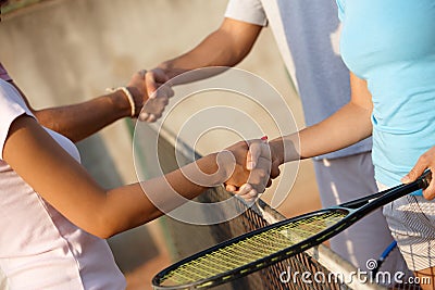 Shaking hands on tennis court Stock Photo