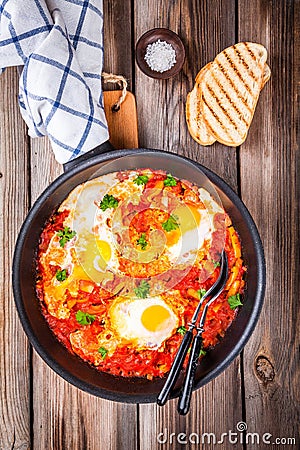 Shakshuka. Fried eggs with tomato, paprika and parsley Stock Photo