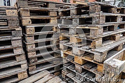 Shallow depth of field selective focus image with a pile of wooden EPAL Euro pallets stacked outdoors Editorial Stock Photo