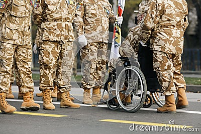 Shallow depth of field selective focus image with Romanian army veteran soldiers, of which one is injured and disabled, sitting Editorial Stock Photo
