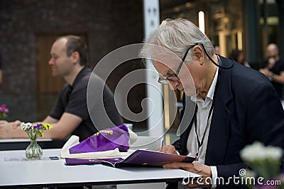 Shallow focus of Richard Dawkins reading a book at a conference about Dissent in Koln, Germany Editorial Stock Photo