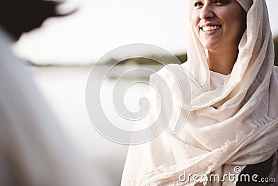 Shallow focus shot of a female wearing a biblical robe while talking to Jesus Christ Stock Photo