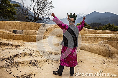 Shaman summoning spirits at the mineral terraces in Baishutai, China. The magic, incantation, occultism. Editorial Stock Photo