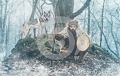 Shamanic man playing on shaman frame drum in the nature. Stock Photo