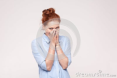 Shame and liar concept. Red haired woman covering mouth with bot Stock Photo