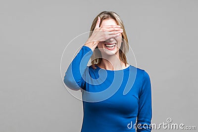 So shameful, i`d rather not watch this! Portrait of bashful positive woman covering eyes with hand. isolated on gray background Stock Photo