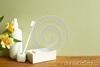 Shampoo bottle, toothbrush, soap, flower on wooden table Stock Photo