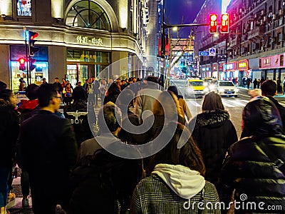 SHANGHAI, CHINA - 12 MAR 2019 â€“ Blurred motion shot of pedestrians crossing the street along East Nanjing Road Nanjing Dong Lu Editorial Stock Photo