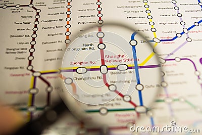 Shanghai Railway Station metro station on a printed paris metro map under a magnifier lens Stock Photo