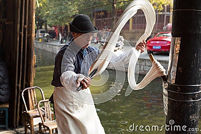 SHAOXING , CHINA: Chinese man making and selling traditional handmade dragon`s beard candy at old town of Anch Editorial Stock Photo