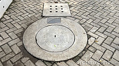 The shape of the concrete drain cover with holes on the heringbone motif conblock floor Stock Photo